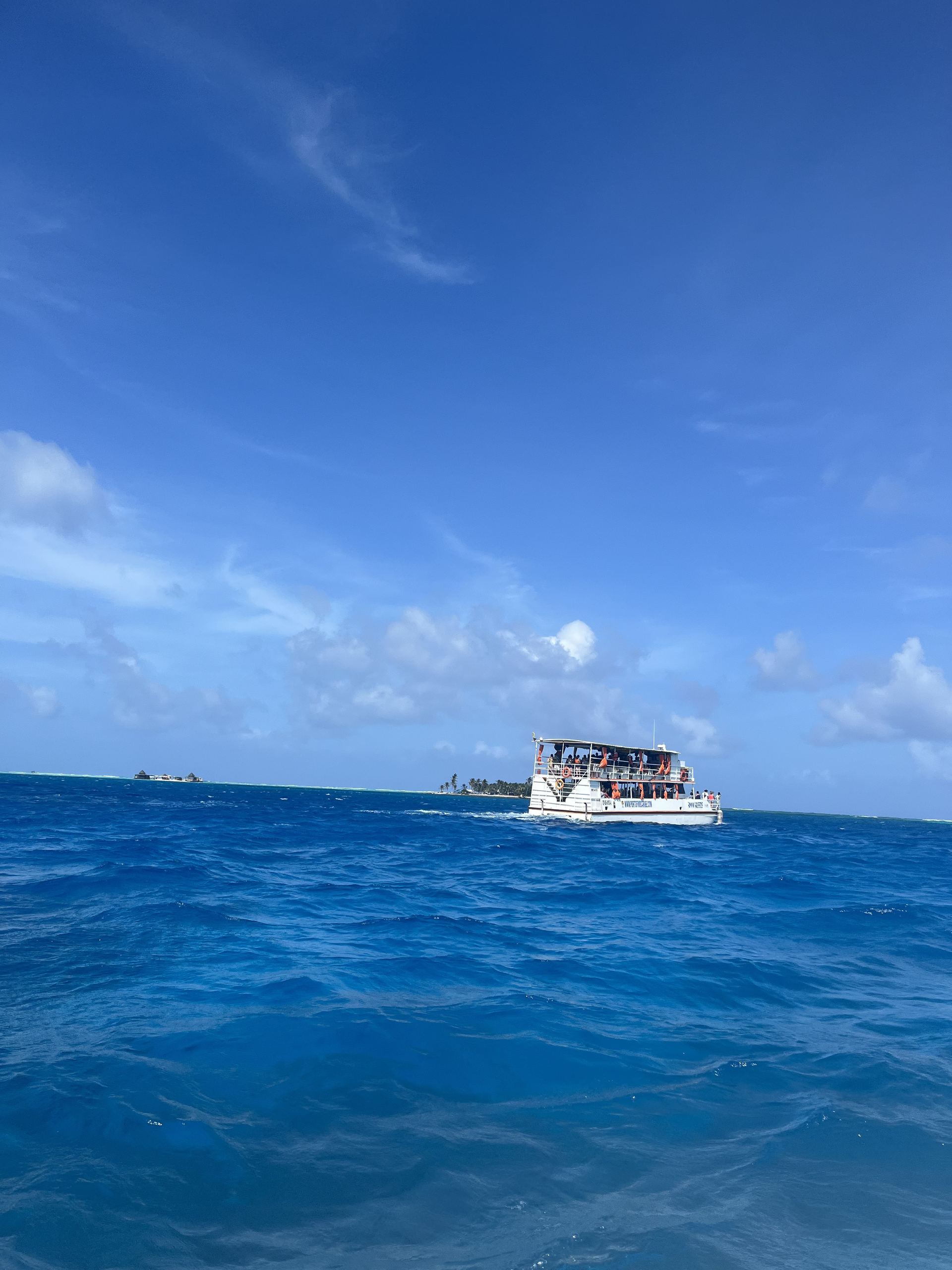 A small boat on the Caribbean off Providencia with a tiny island in the distance